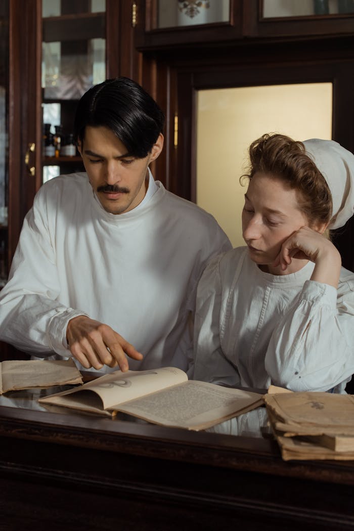 Two individuals dressed in vintage attire analyzing books in a retro pharmacy.